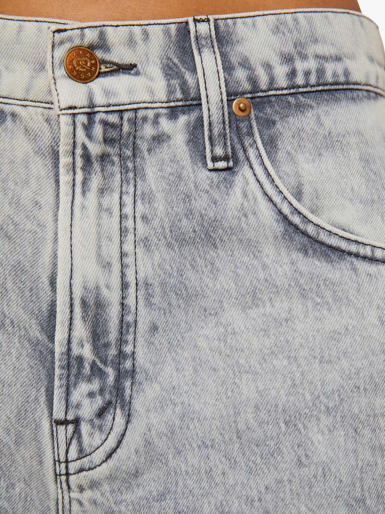 Detailed view of a woman in acid-washed grey wide-leg pants feature a super high rise, long 31-inch inseam, cargo-inspired patch pockets and a loose, slightly baggy fit.