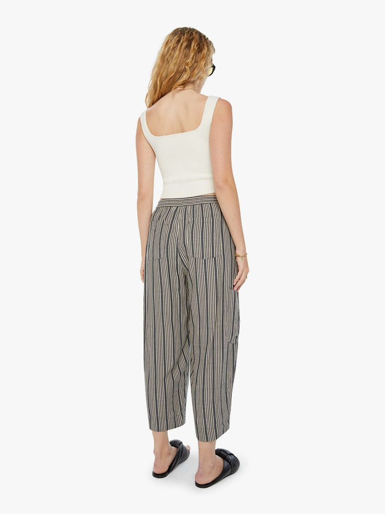 Back view of a woman cropped trousers with an elastic waistband, a tapered wide leg, cargo patch pockets in dark grey with a white stripe pattern.