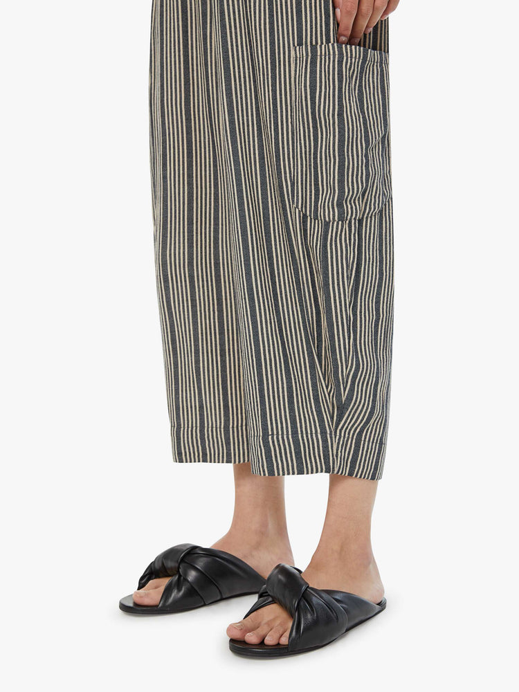 Hem view of a woman cropped trousers with an elastic waistband, a tapered wide leg, cargo patch pockets in dark grey with a white stripe pattern.