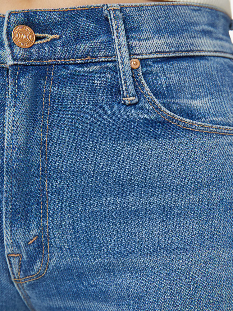 Swatch view of a woman in mid blue mid-rise flare with a 34-inch inseam and a frayed hem.