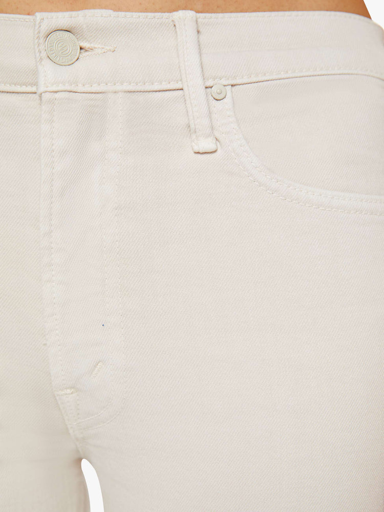 Swatch  view of a woman in a off white cream color mid-rise pants with a flared leg and a 28.25-inch inseam with a clean hem. 