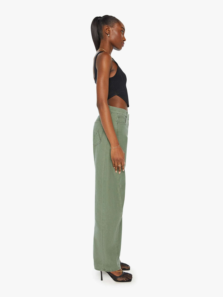 Side view of a woman in army green high-waisted pants with a full barrel leg and clean hem.