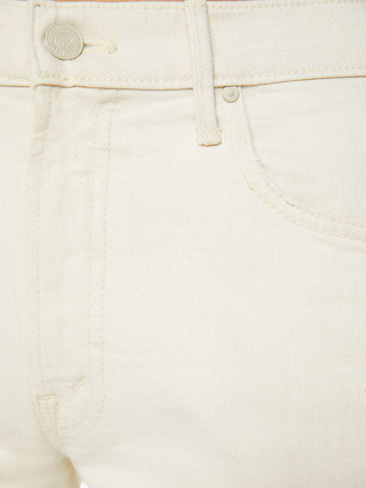 Swatch view of a woman in a creamy white mid-rise  jeans with a loose fit, wide leg and ankle-length inseam with a frayed hem. 