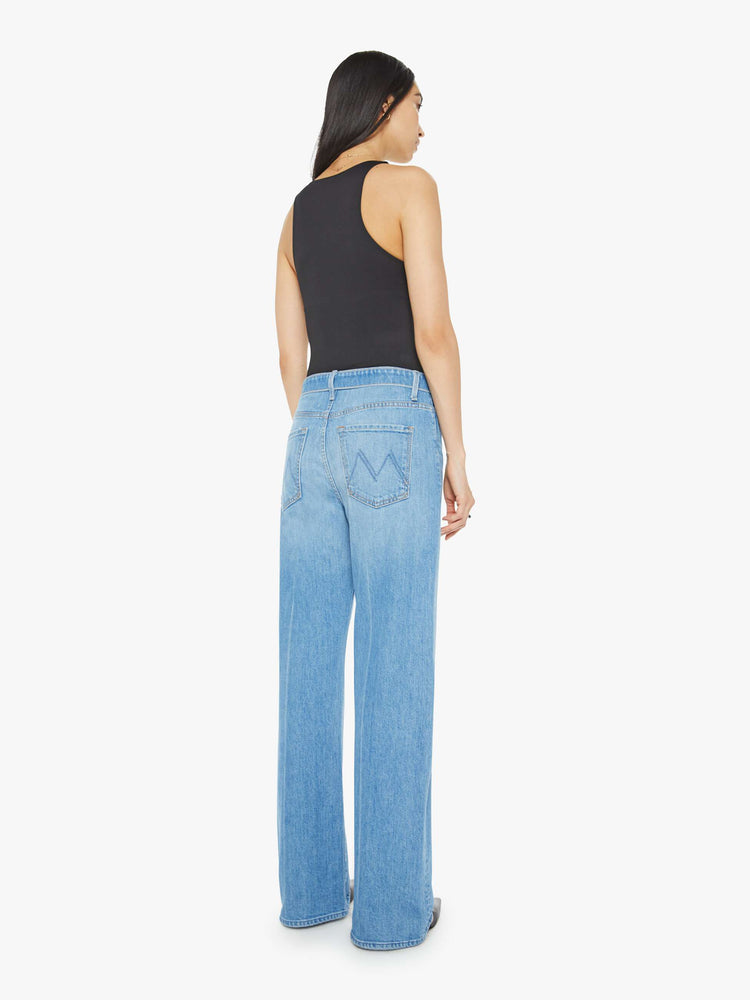 Back view of a woman in mid blue wash high-rise, straight-leg jeans have a foldover waistband, long 32-inch inseam and a loose fit. 