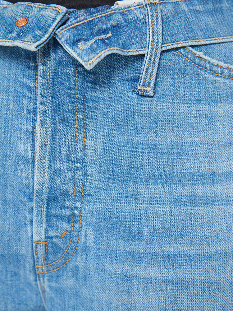 Swatch view of a woman in mid blue wash high-rise, straight-leg jeans have a foldover waistband, long 32-inch inseam and a loose fit. 