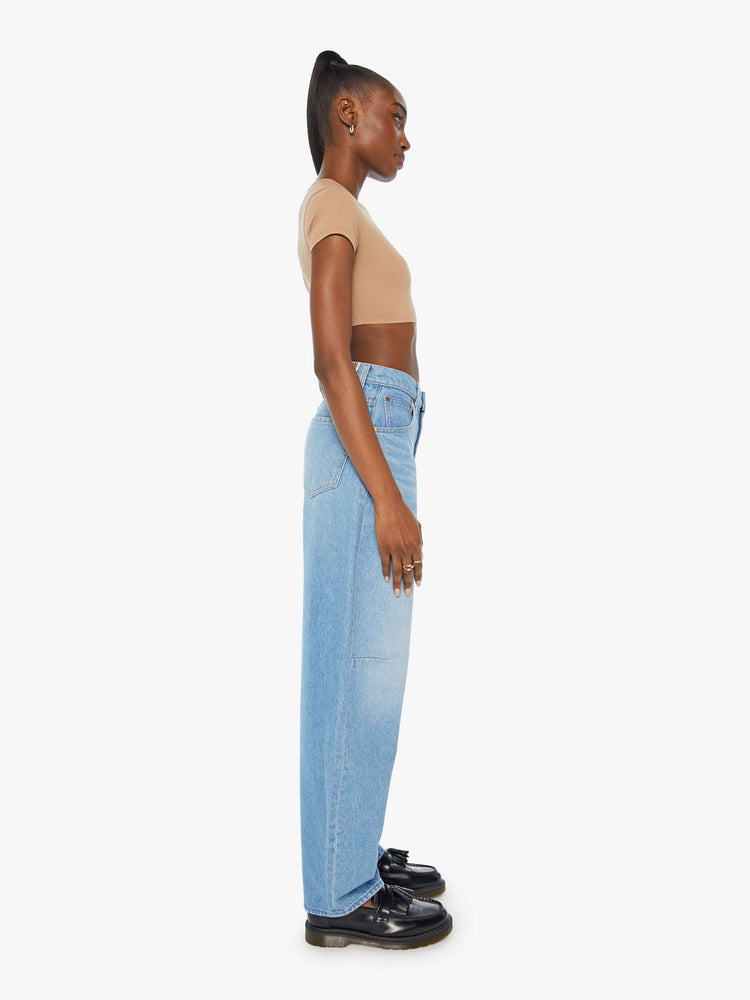 Side view of a woman in super high rise wide leg in a vintage blue wash.