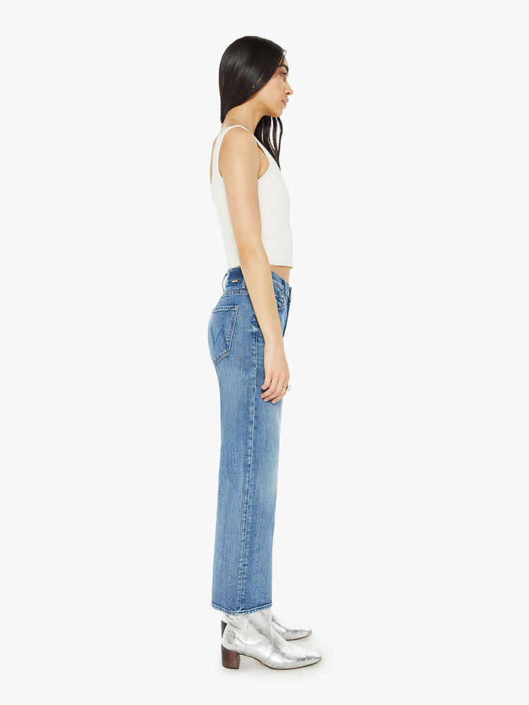 Side view of a med blue mid-rise jeans with a loose fit, wide leg and ankle-length inseam with a clean hem.