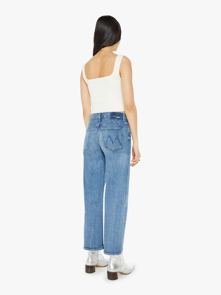 Back view of a med blue mid-rise jeans with a loose fit, wide leg and ankle-length inseam with a clean hem.