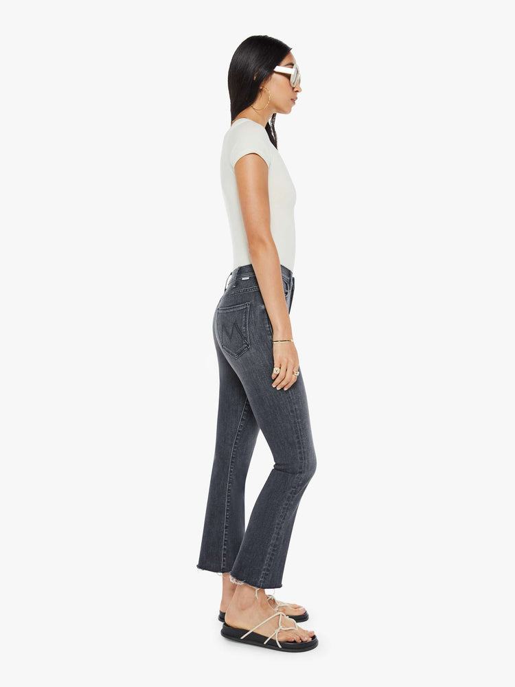 Side view of women’s faded black cropped bootcut denim.