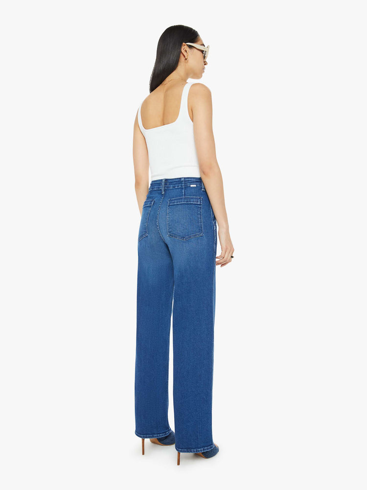 Back view of a woman in a super high-waisted pants with a loose straight leg, side slit pockets, long 31-inch inseam and a clean hem in dak blue.