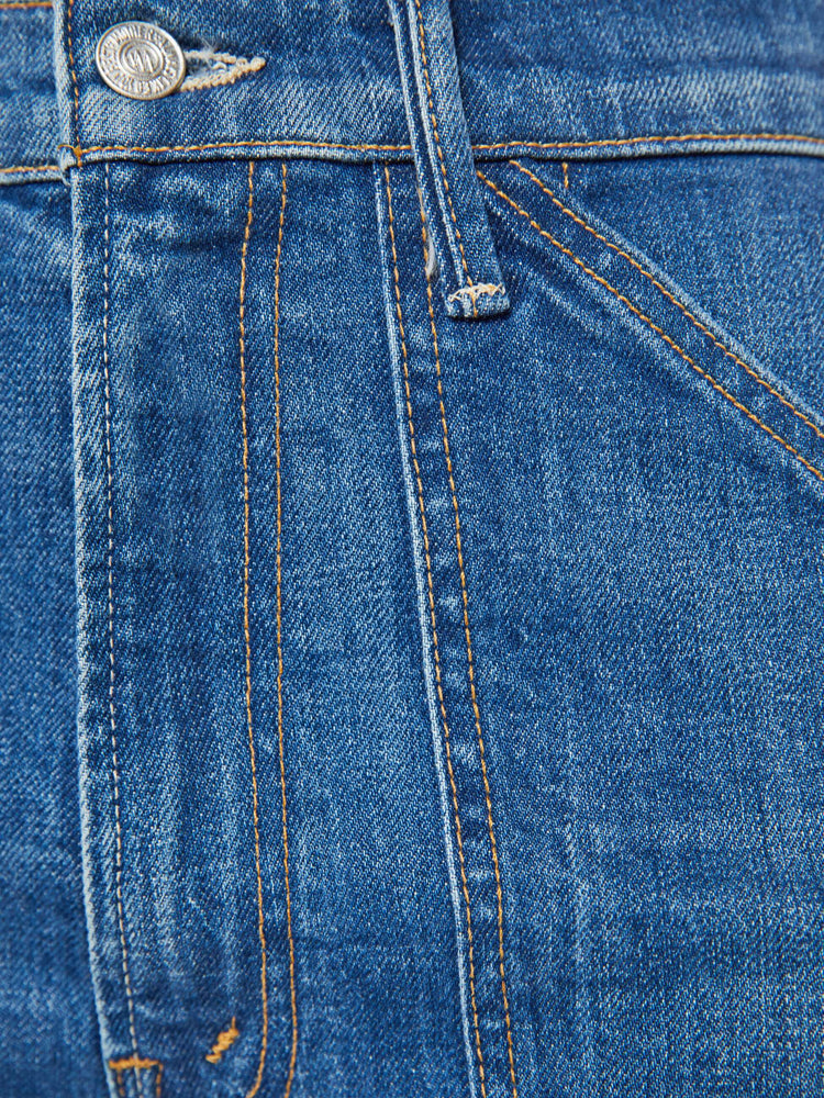 Swatch view of a woman in a mid blue wash wide-leg jeans with a super high rise, oversized front patch pockets, seamed details throughout and a long 32-inch inseam with a clean hem.