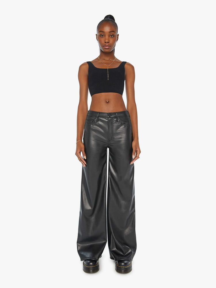 Front view of a woman black faux leather wide  leg pants with a high rise, long 32-inch inseam and a clean hem. 