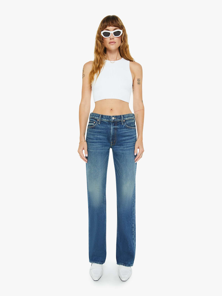 Front view of a woman in a  straight leg with a bit of a kick, the jean features a mid rise, full-length inseam and clean hem in a classic blue.