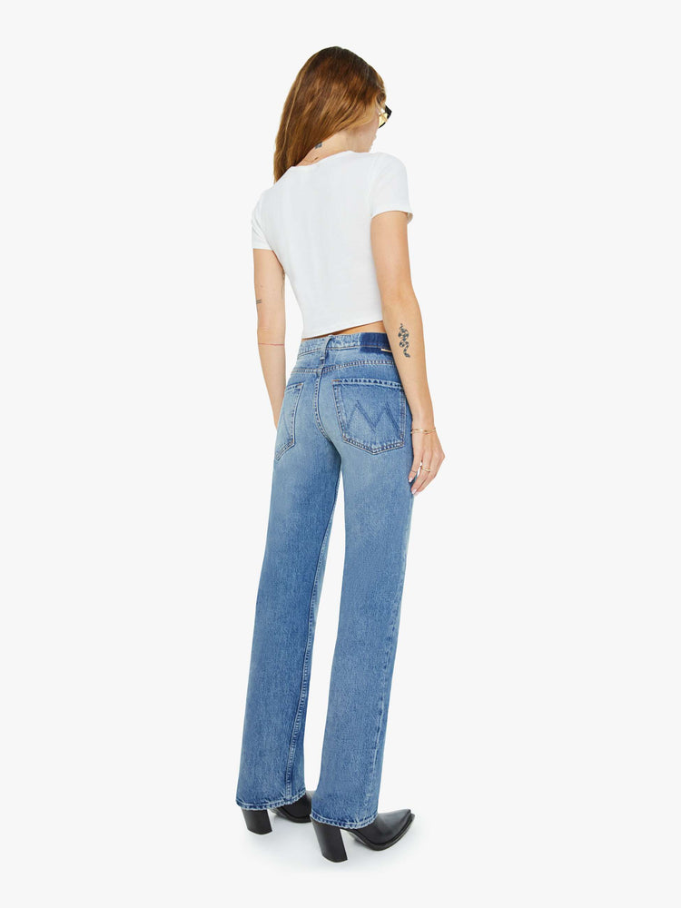 Back view of a woman in a  straight leg with a bit of a kick, the jean features a mid rise, full-length inseam and clean hem in med blue wash.