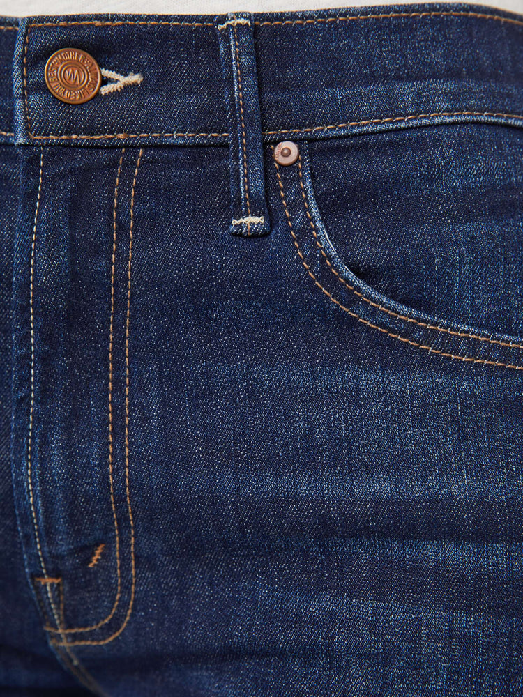 Swatch view of a woman in a dark blue high-waisted bootcut is cropped at the ankle with a frayed step-hem.