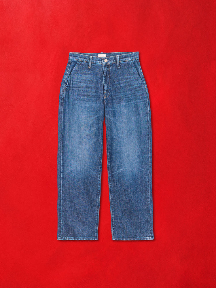 A flat product image of a dark blue denim jean against a red background.