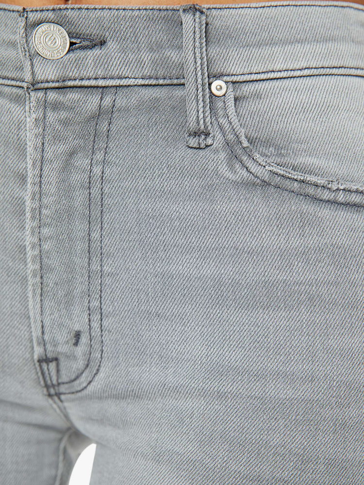 Swatch view of a woman in grey mid-rise straight leg with an ankle-length inseam and a frayed hem. 