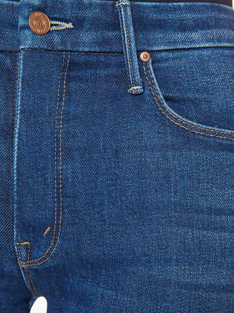 Swatch view of a woman in a dark blue skinny high rise with an ankle-length inseam and a clean hem.