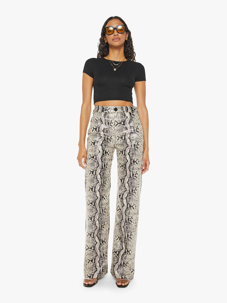 Front view of a woman super high-waisted pants with a loose fit, wide leg and a long 34-inch inseam with a clean hem in a cream and black snake print.