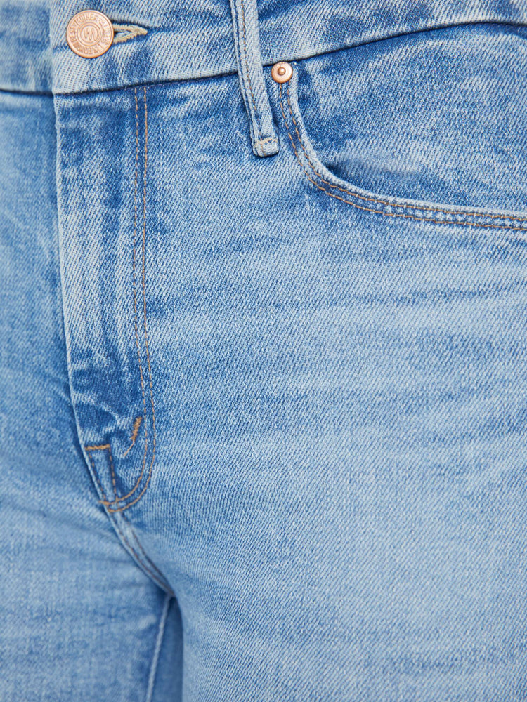 Swatch view of a woman in a light blue wash high-rise skinny jean has an ankle-length inseam and a frayed step hem.