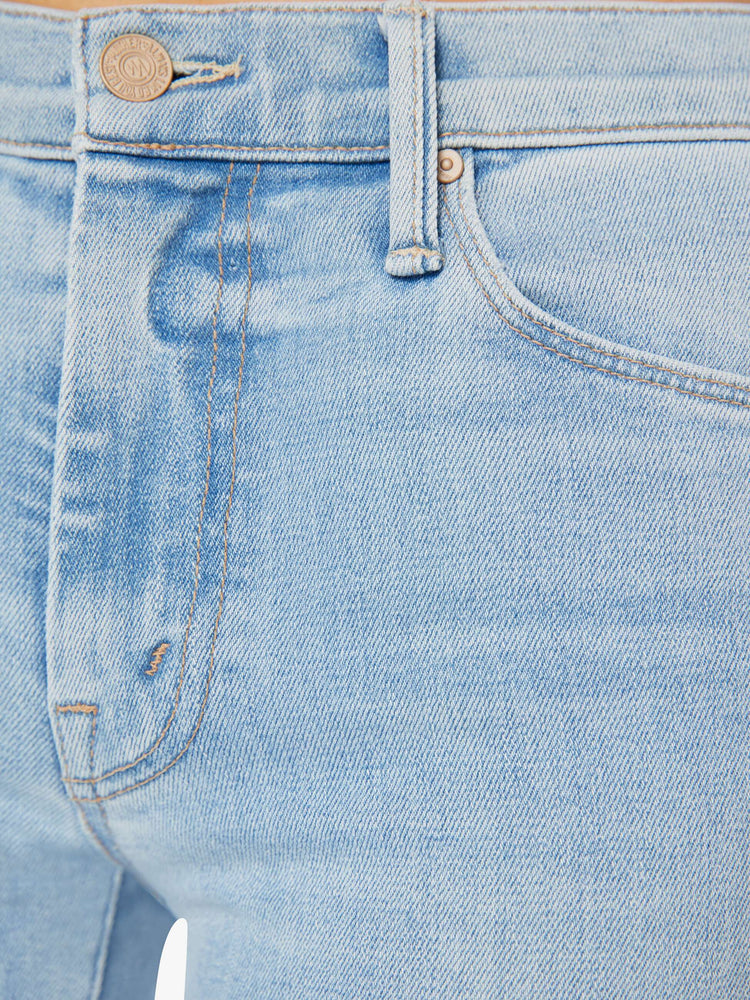 Swatch view of a woman in a mid-rise flare has a 31-inch inseam with a frayed hem in a light blue wash.