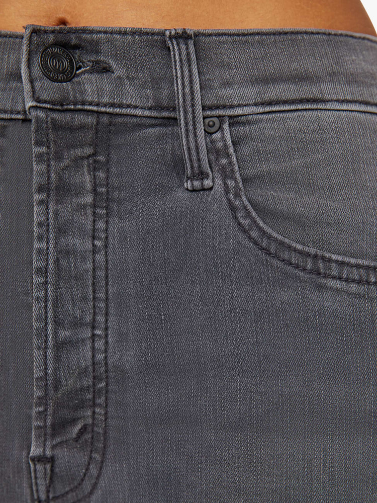 Swatch view of a woman in high-rise flare with a button fly and a clean ankle-length hem dark grey wash.