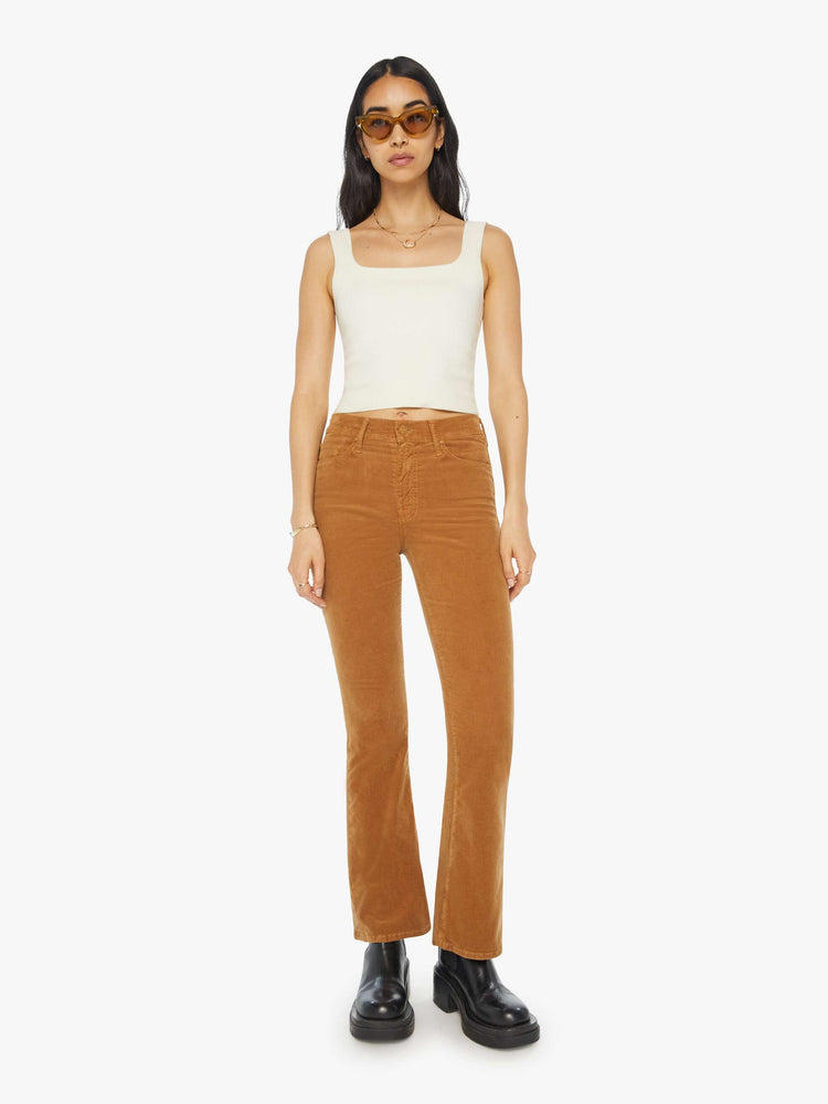 Front view of a woman in a mid rise with a 31-inch inseam and a clean hem in a golden orange corduroy.