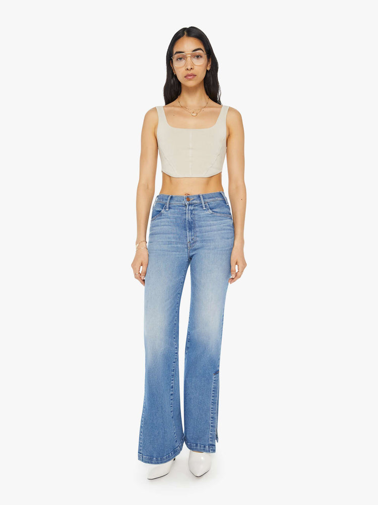 Full front view of a woman in light blue high-rise wide-leg jeans with a long 32-inch inseam and a thick side-slit hem.