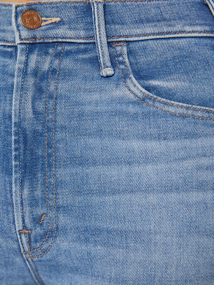 Detailed view of a woman in light blue high-rise wide-leg jeans with a long 32-inch inseam and a thick side-slit hem.