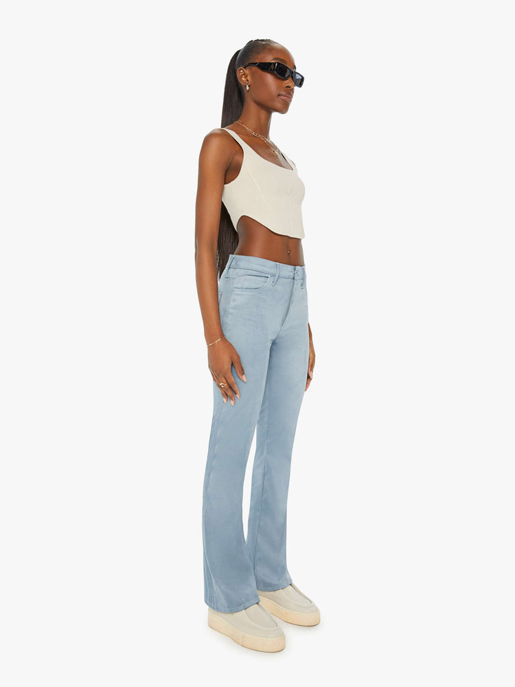 Angled front view of a woman in baby blue faux seudue high-rise flares with a long 32-inch inseam and a clean hem.