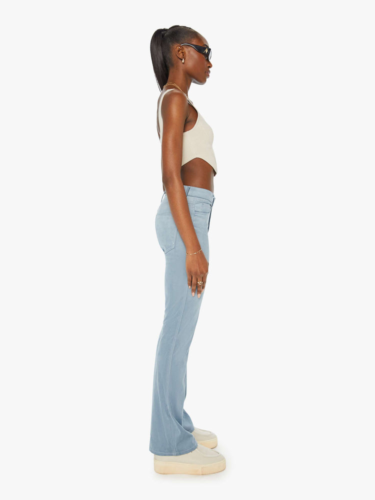 Side view of a woman in baby blue faux seudue high-rise flares with a long 32-inch inseam and a clean hem.