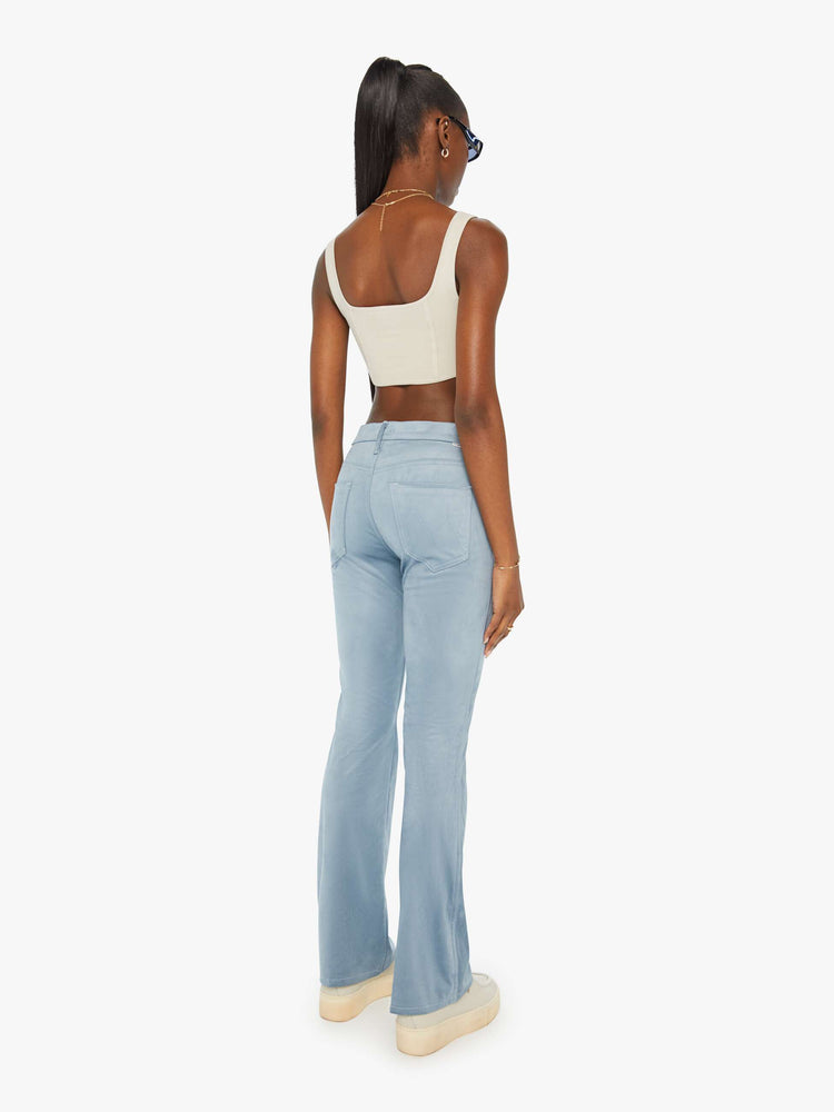 Back view of a woman in baby blue faux seudue high-rise flares with a long 32-inch inseam and a clean hem.