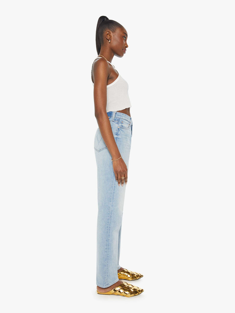 Side view of a woman high-waisted  straight-leg jeans with a 30-inch inseam and a clean hem in a light blue denim.