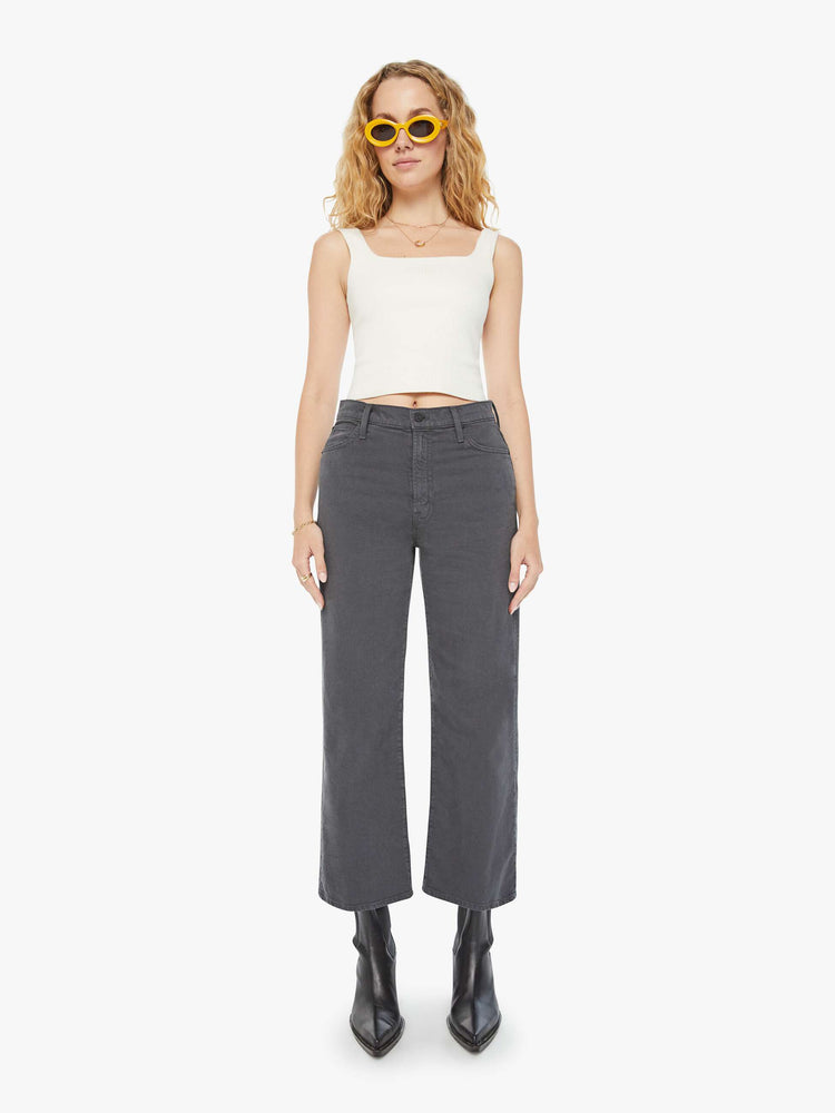 Front view of a woman in faded dark grey lower rise pants with a loose straight leg and a clean ankle-length inseam.