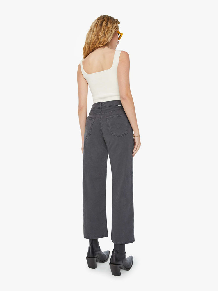 Back view of a woman in faded dark grey lower rise pants with a loose straight leg and a clean ankle-length inseam.