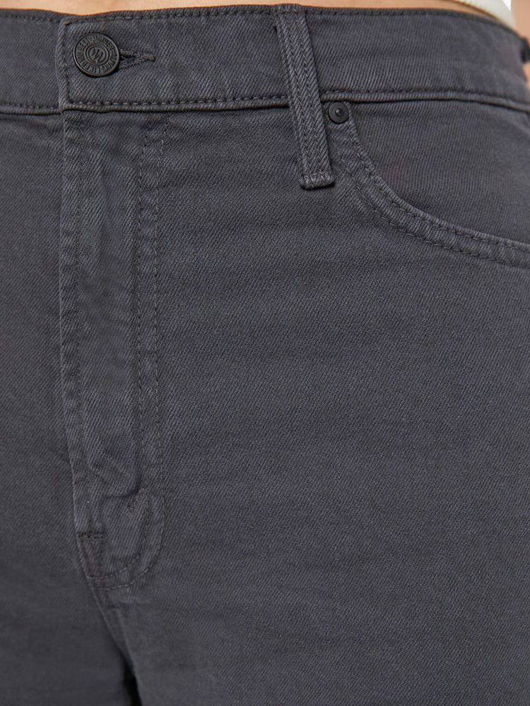 Detailed view of a woman in faded dark grey lower rise pants with a loose straight leg and a clean ankle-length inseam.