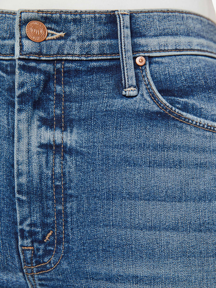 Swatch  view of a medium blue flare with distressed knees and a long clean hem.