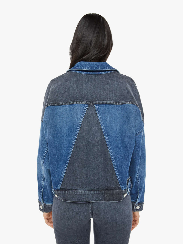 Back  view of a woman in med blue wash with black  denim jacket with drop shoulders, angled patch pockets on the chest and a classic fit. 