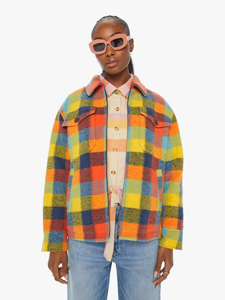 Front view of a woman in a colorful plaid print collared zip-up jacket with oversized patch pockets, drop shoulders and a boxy fit.