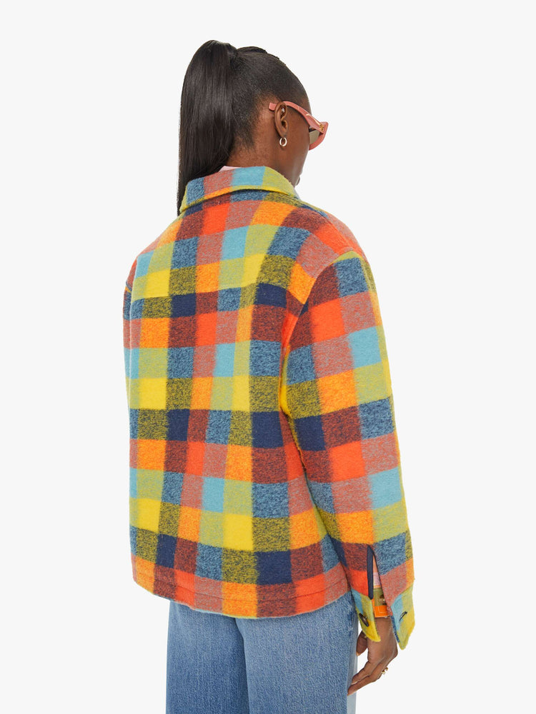 Back view of a woman in a colorful plaid print collared zip-up jacket with oversized patch pockets, drop shoulders and a boxy fit.