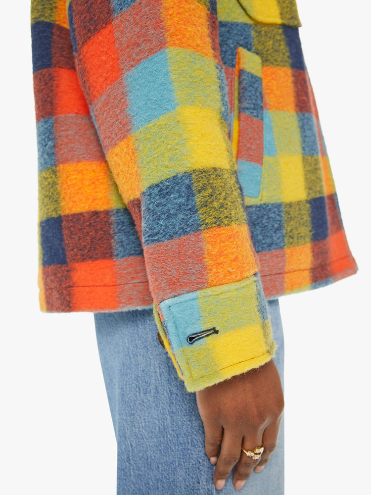 Detailed view of a woman in a colorful plaid print collared zip-up jacket with oversized patch pockets, drop shoulders and a boxy fit.