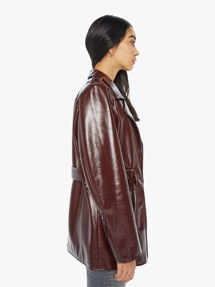 Side view of a woman in a buttery faux leather oversized faux-leather jacket with a notched collar, belted waist, zip pockets and an extra-long hem.