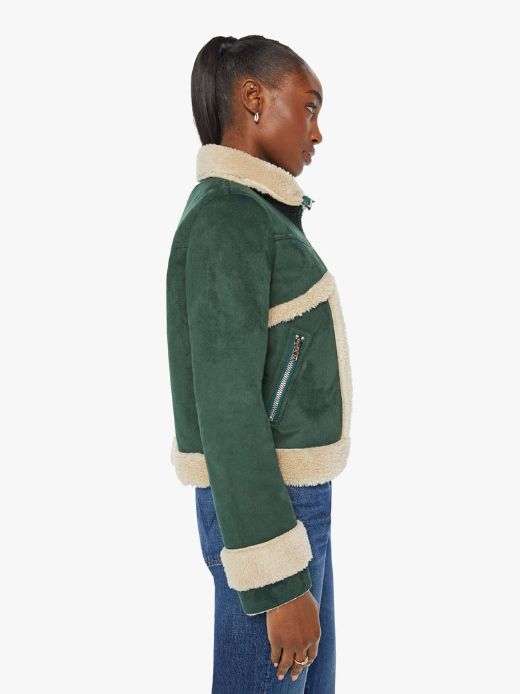 Side view of a woman in a dark green faux suede with cream faux sherpa collared zip-up jacket with a slightly cropped hem and a boxy fit.