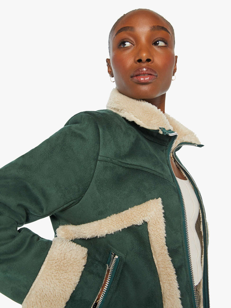 Close up view of a woman in a dark green faux suede with cream faux sherpa collared zip-up jacket with a slightly cropped hem and a boxy fit.