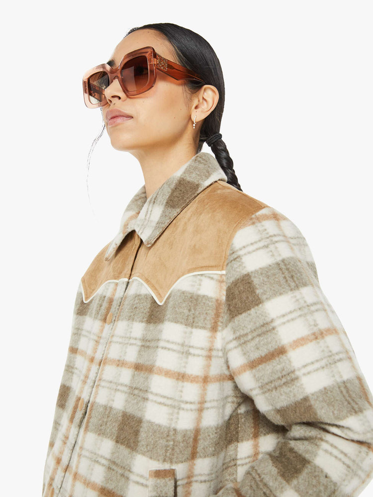 Close up view of a tan plaid collared jacket with a Western-inspired yoke and snaps down the front. 