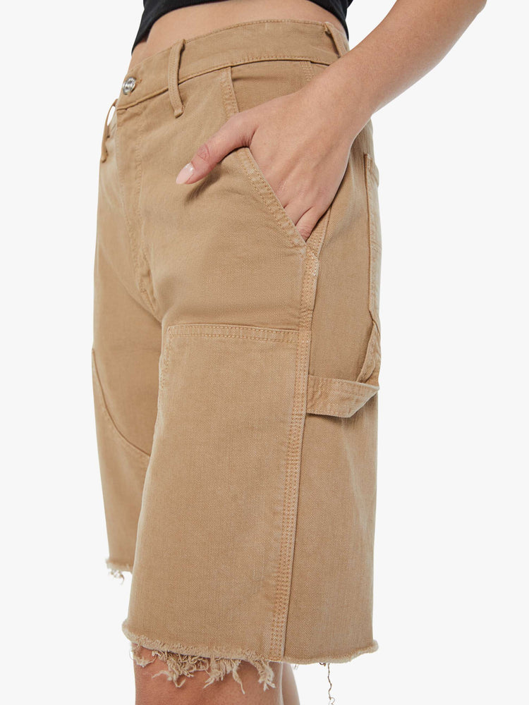 Swatch view of a woman in dark khaki high-waisted bermuda shorts designed to sit lower on the hips with a long 9.5-inch inseam and a frayed hem.