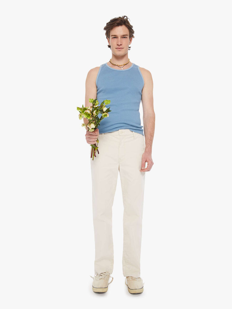 Front view of a man in an off white  pants with a mid rise, slit pockets and a 31-inch inseam with a clean hem. 
