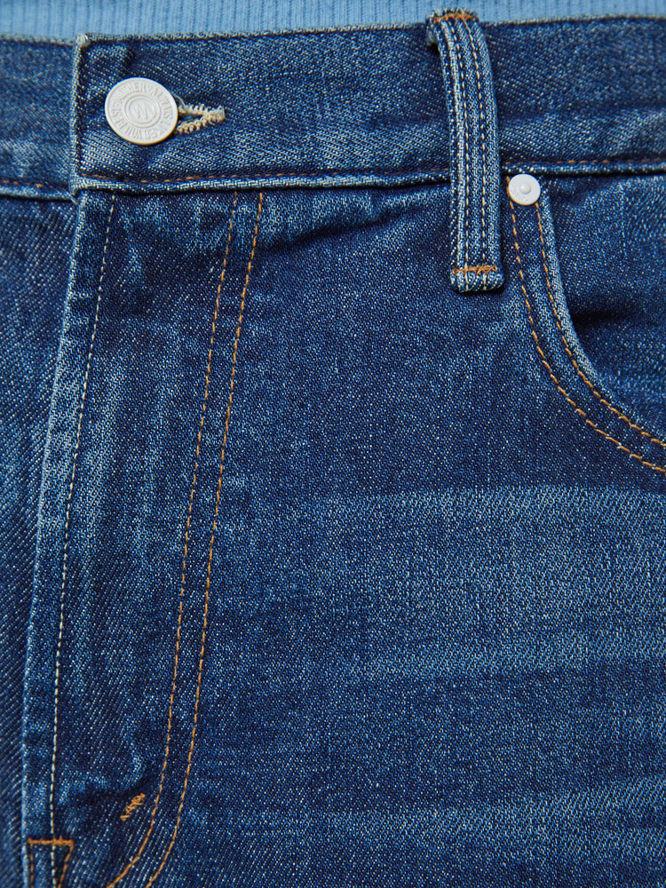 Swatch view of a man in a mid-rise bootcut with a 31-inch inseam and a clean hem in a dark blue wash.