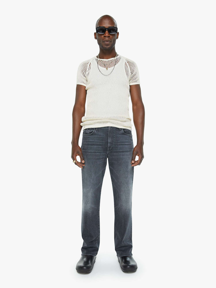 Front view of a man in a mid-rise bootcut with a 31-inch inseam and a clean hem in a faded black wash.