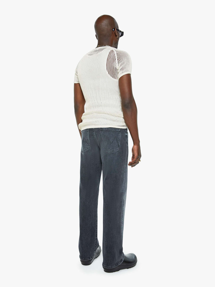 Back view of a man in a mid-rise bootcut with a 31-inch inseam and a clean hem in a faded black wash.